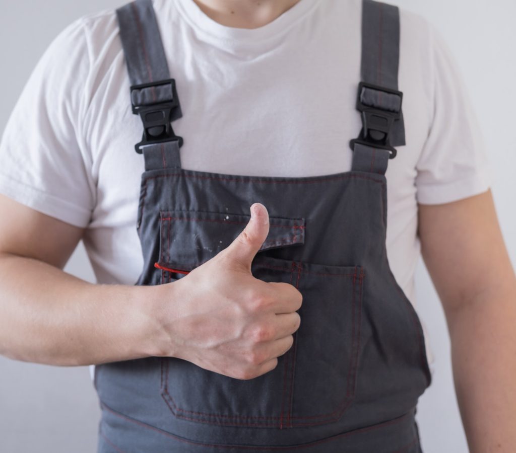 male worker or builder in overalls showing thumbs up white background
